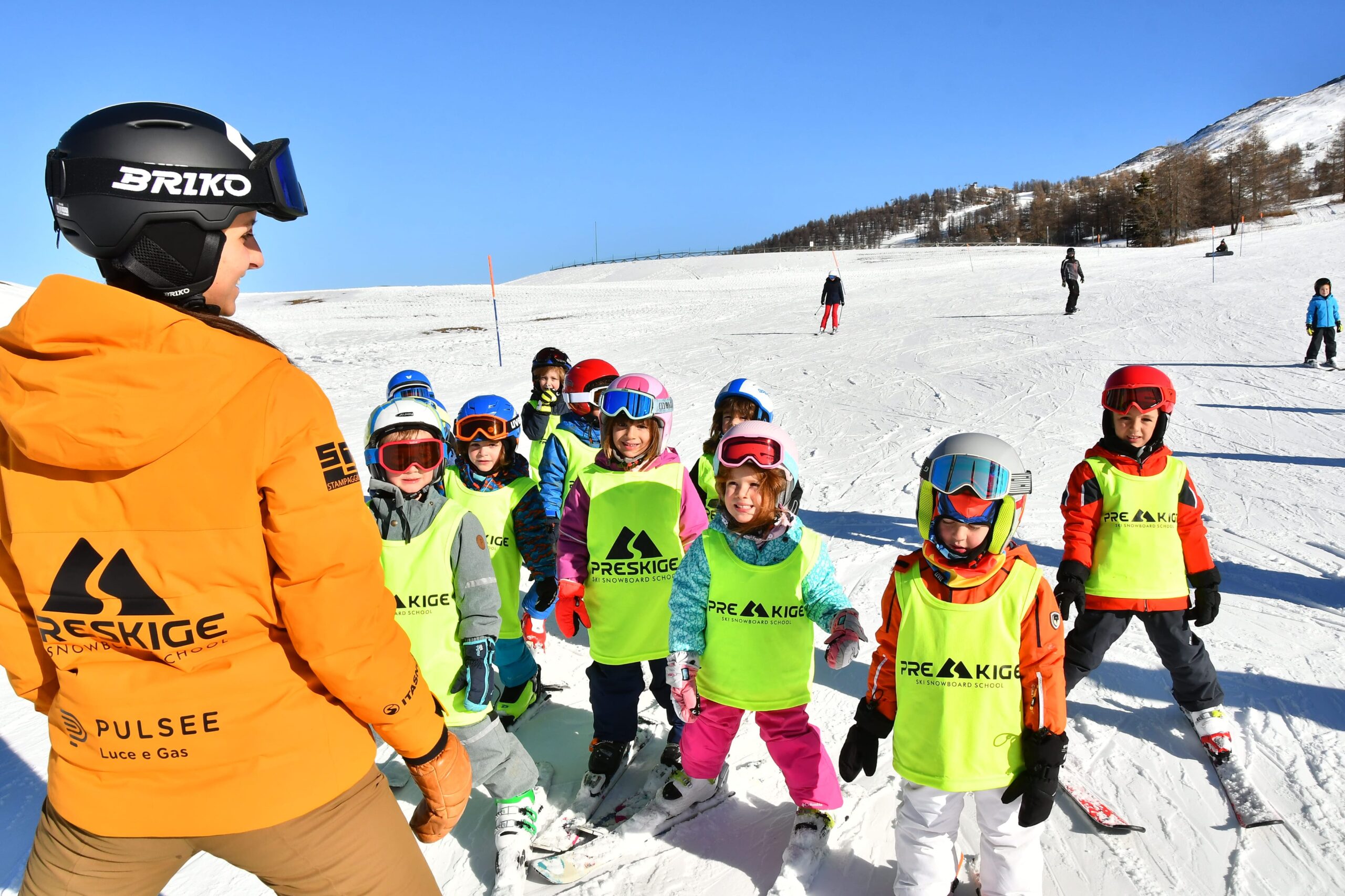 Maestra Preskige con un gruppo di bambini in pettorina sugli sci a Sestriere