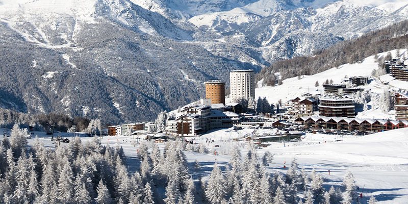 Il paese di Sestriere con le sue torri, tra le piste e i boschi innevati della Via Lattea