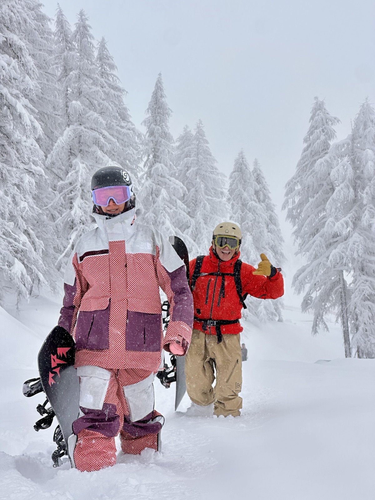 Due rider camminano in un bosco innevato dopo una discesa in neve fresca