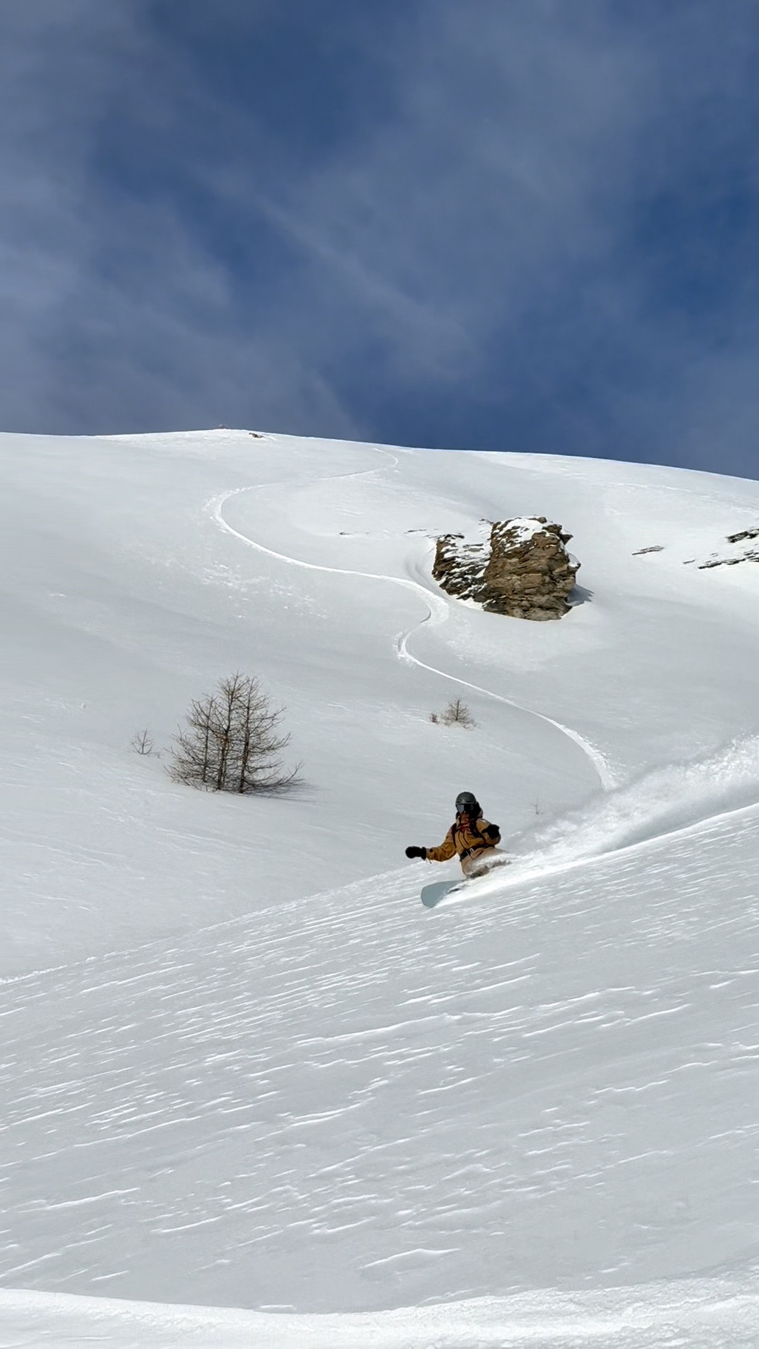 Curva backside nel powder su un ampio pendio della Via Lattea, con la linea tracciata nella neve