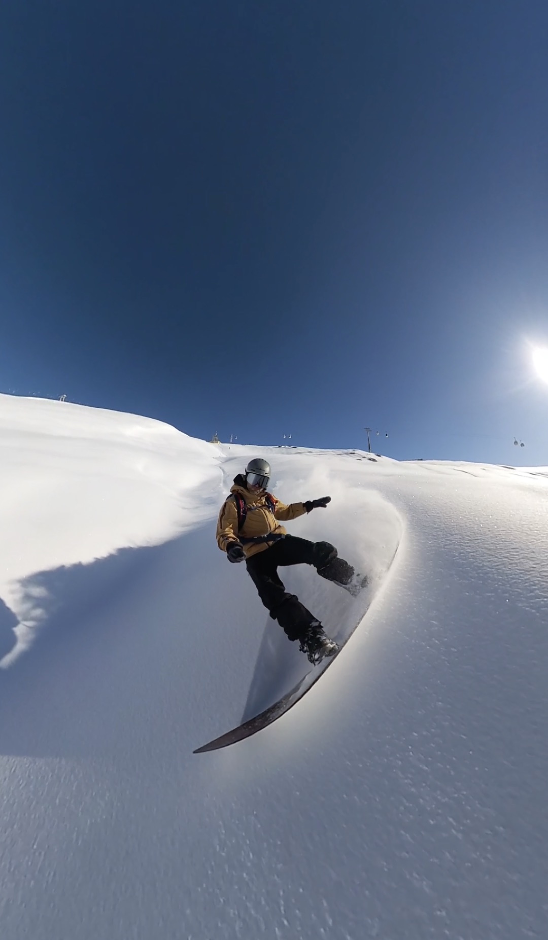 Rider in freeride verso l'obiettivo, con i piloni degli impianti della Via Lattea sullo sfondo