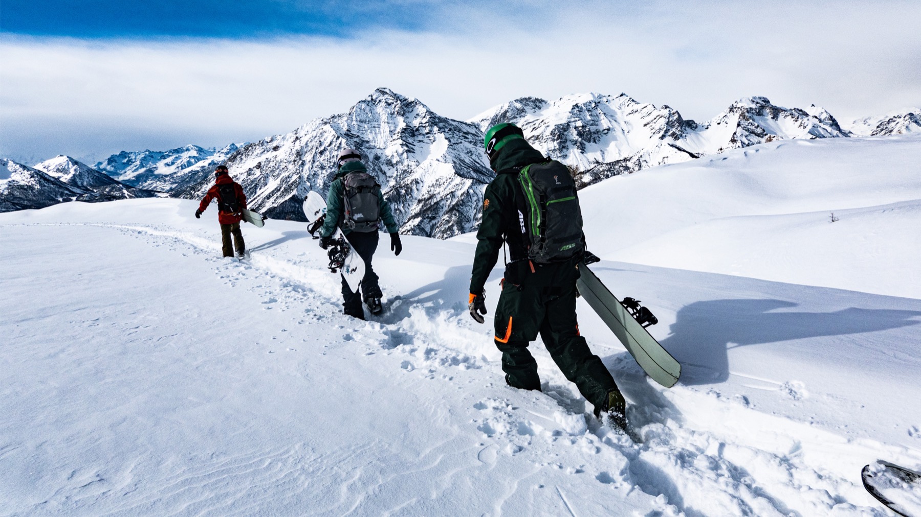 Freerider in traversata su una cresta della Via Lattea, ampio panorama di vette innevate